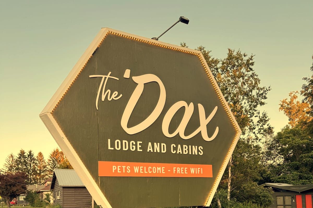 The Dax Lodge and Cabins roadside sign — pets welcome, free WiFi